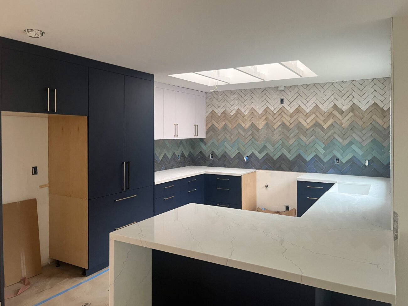 new build kitchen installation with skylights and modern statement backsplash